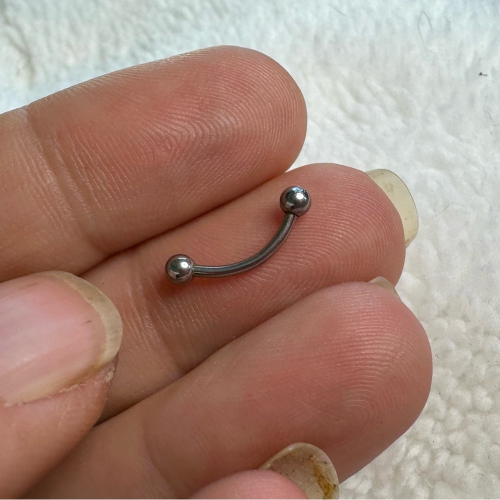 Curved barbell with ball ends.